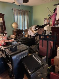 Cluttered bedroom with belongings stacked before treatment